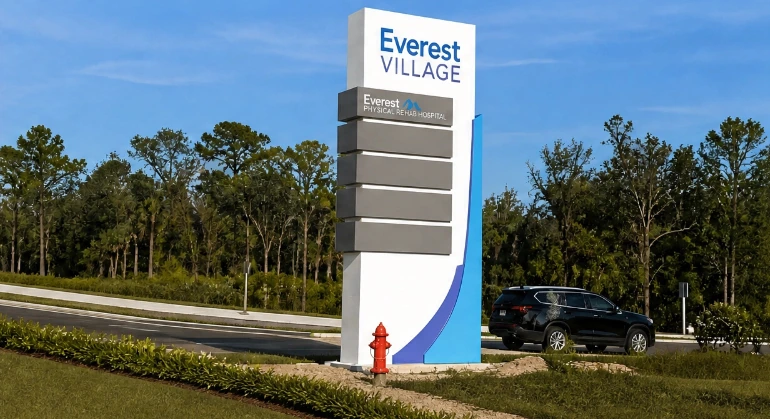 The Everest Village monument sign at the development entrance on US Highway 92, with tenant panels including Everest Physical Rehab Hospital.